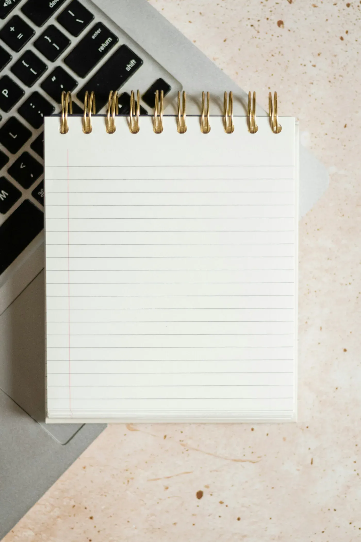Notepad and laptop on a desk
